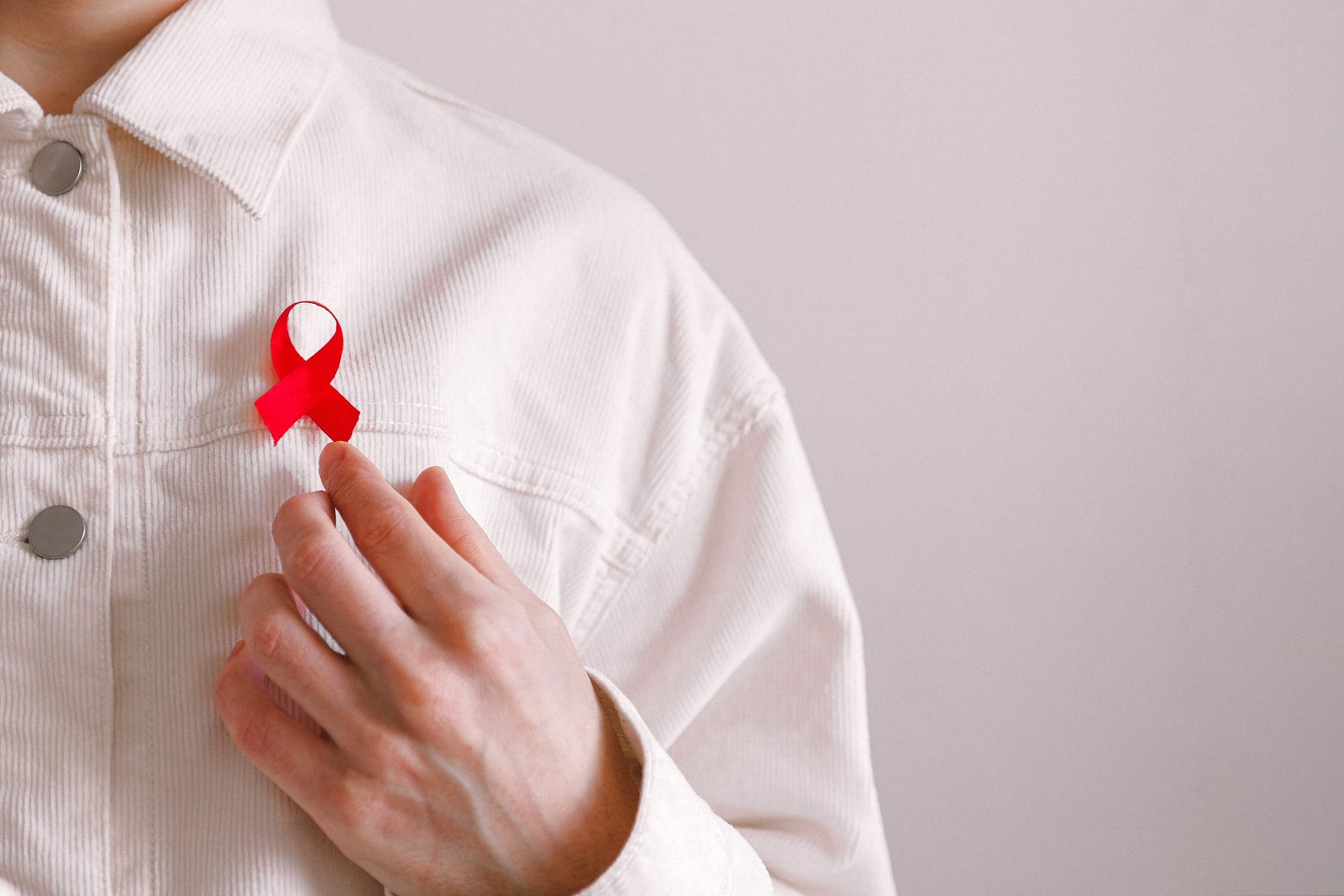 Άνδρας με κόκκινη κορδέλα στο πουκάμισό του για την Παγκόσμια Ημέρα κατά του AIDS